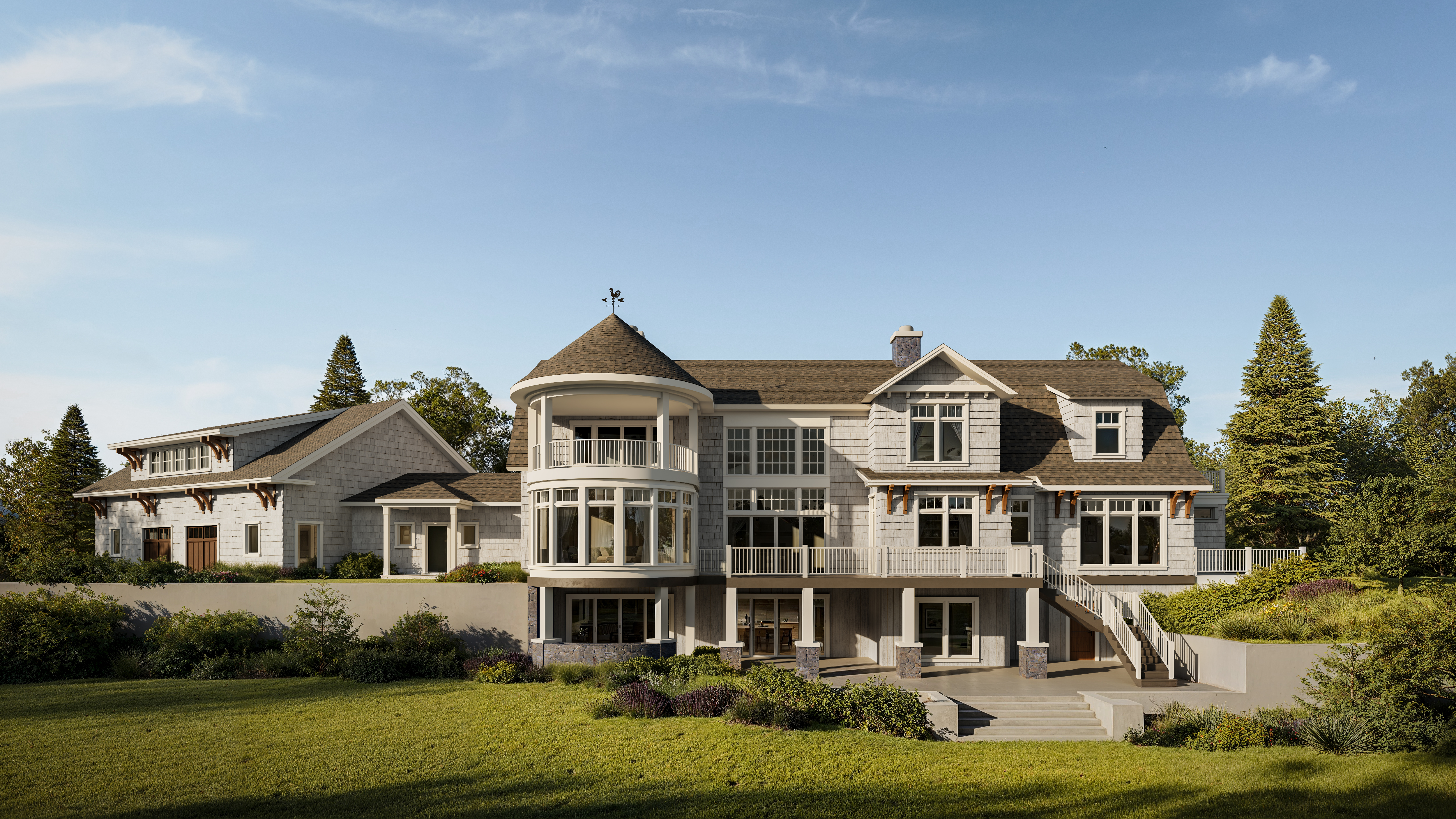 Large lakeside home with shingle siding and a turret.