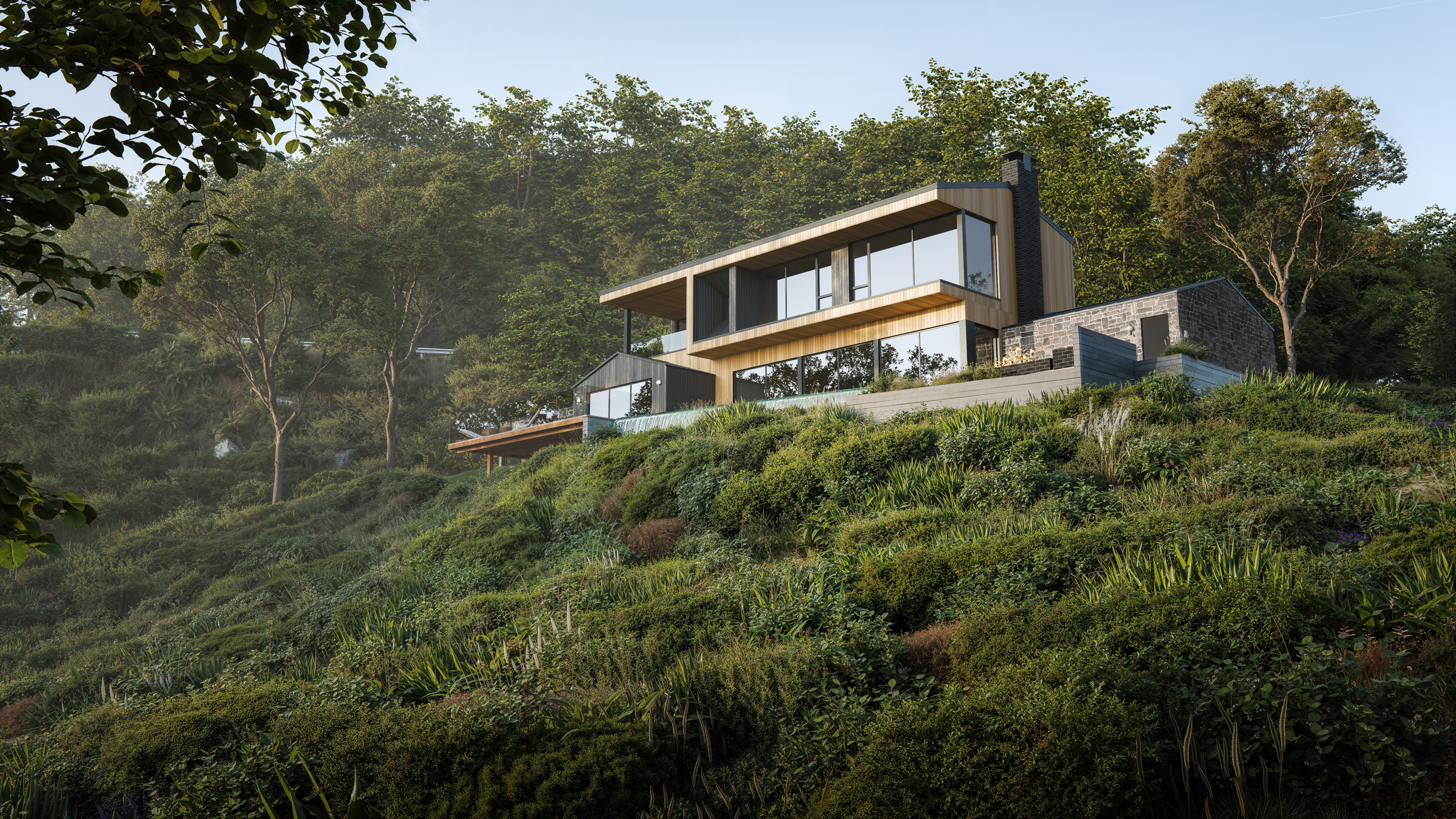 Modern hillside home with wood and glass architecture nestled among lush greenery.
